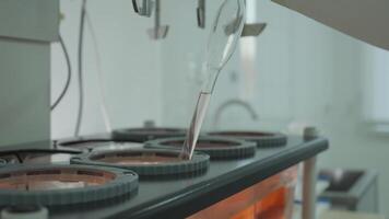 Laboratory technician in protective clothing taking chemical samples from automatic mixer in laboratory video