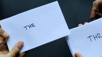 Concept of someone giving a salary bonus envelope that says THR, this allowance is given to employees ahead of the Eid al-Fitr video