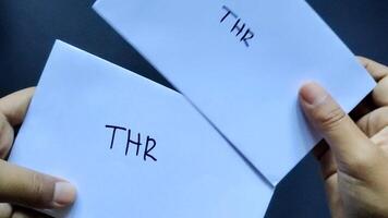 Someone dropped a white envelope labeled THR with a black background. This envelope contained salary allowances given to Muslim employees before Eid al-Fitr. video