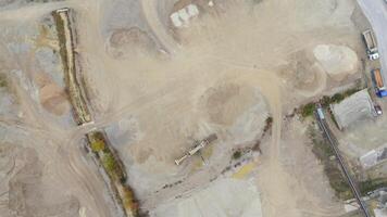 Aerial view of active sand quarry in Germany, surrounded by industrial zones. Heavy machinery operates in foggy autumn atmosphere, emphasizing raw, industrial landscape and ongoing extraction work. video
