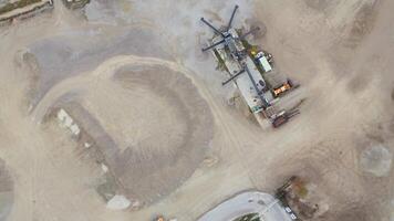 Aerial view of active sand quarry in industrial zone in foggy autumn Bavaria, Germany. Heavy machinery operates across sprawling site, creating stark, atmospheric scene of industry and raw materials. video