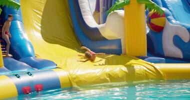 Child Sliding on Colorful Inflatable Water Slide video