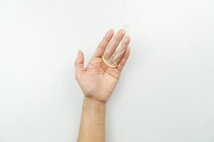 A hand holding a plastic object with a white background photo