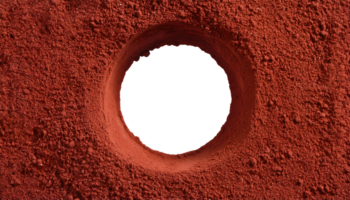top view of a hole in red ground, textured soil surface, circular pit, deep excavation, earthy terrain, rough granular surface, crater-like formation, on isolated background png