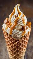 Ice cream with caramel sauce on top of a waffle cone photo