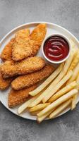 Chicken nuggets and fries on a plate with ketchup photo