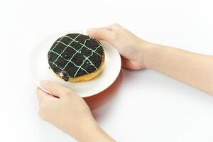 A person holding a donut on a plate photo