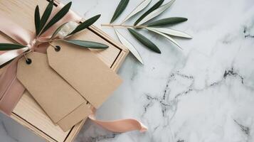 Gift box with tags and olive branch on marble background photo
