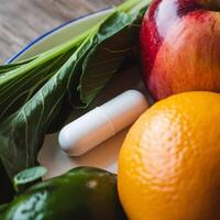 A white pill on a plate with apples, oranges and vegetables photo