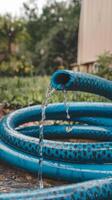 A blue hose with a water stream coming out of it photo