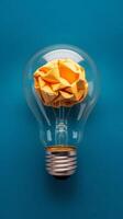 An idea light bulb with a yellow paper brain inside photo