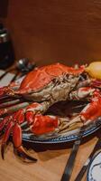 A large crab sitting on a plate with a knife and fork photo