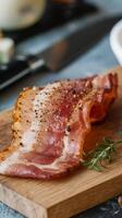 Bacon on a cutting board with a knife and a bowl of butter photo