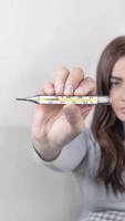 Woman caught a cold, got sick, she shows mercury thermometer with a temperature of 37,7 C. vertical animation banner Camera approach video
