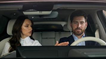 Woman female girl consultant trader talking consult client buyer sitting together in salon of new car automobile choosing vehicle in showroom man businessman guy business male buying auto test drive photo