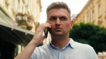 Confused man businessman tourist traveler talking mobile phone outdoor stressed displeased Caucasian male guy smartphone problem loss connection bad signal internet wi-fi roaming cell trouble in city photo