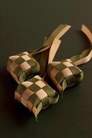 three small woven bags with ribbons on a black surface photo
