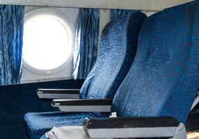 Two empty airplane seat seats and window in a passenger airplane close up photo
