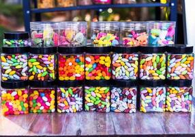 Many colorful candy and lollipops with gum in jars. photo