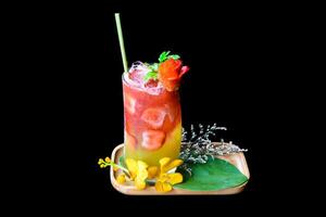 Fresh summer drink with strawberry jam and orange juice isolated on black background photo