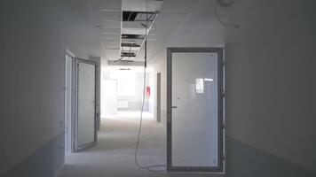 Recently built premises with unfinished inside works. Light system in the process of installation. Wires hanging from the ceiling. video
