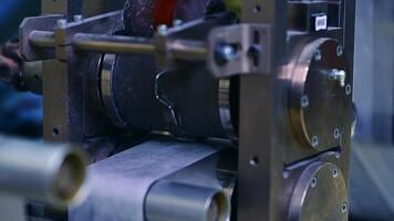 Technological equipment for producing diapers at the factory. Shafts and rollers spinning at conveyor line. Close up. video