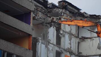 Hydraulic claw of excavator breaks easily the floors of an old building. Falling debris create thick dust cloud at the deconstruction site. video