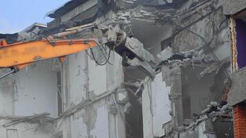 Breaking concrete walls and floors with the help of machinery. Dusty area of destruction site. Powerful claw ruins the house. View from below. video