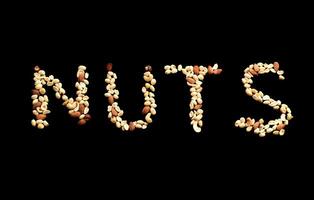 Word arts Nuts made of mixed nuts of almond, hazelnut, peanut and cashew on black background photo