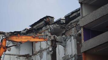 Breaking off the walls of the building with the help of demolishing machinery. Dismantling the building ruined by the natural disaster. video