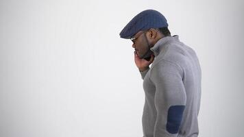 Man talking on phone isolated on background. African man talking on mobile phone standing over grey background video