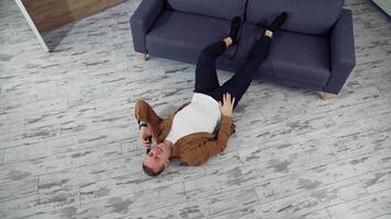 Man relaxing at home on floor. Young man relaxing on the floor and talking on mobile phone video