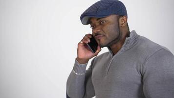 African man talking on phone. Man talking on mobile phone while standing isolated on grey background video