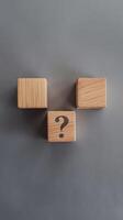 Three wooden blocks with question mark on them photo