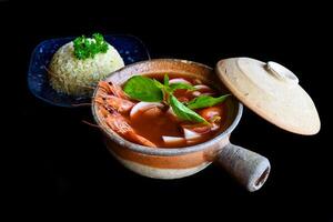Soup tom yum with rice isolated on a black background side view photo