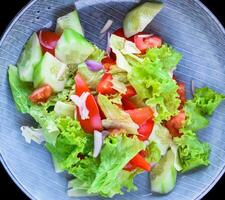 Fresh Vietnamese salad with vegetables on a black background side view photo