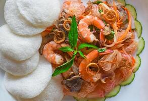 Salad made of shrimps and grapefruit isolated on a black background top view photo