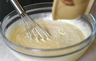 Egg beater in a bowl mixing dough photo