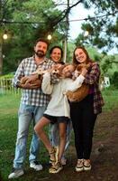 Family members father, mother and 2 daughters with corgi dogs in the forest photo