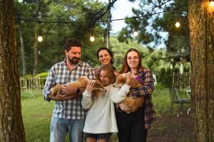 Family members father, mother and two daughters with corgi dogs in the forest photo