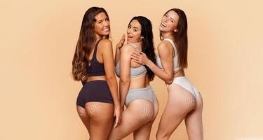 Three diverse women showcase their curves and confidence while engaging in body sculpting and skin care activities. The warm backdrop emphasizes their femininity and promotes a message of self-love. photo