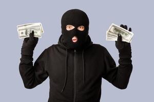 Hands Up. Masked robber being arrested by police for stealing money, standing isolated over white studio background photo