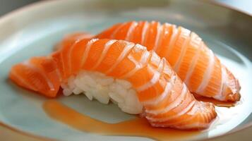 Delicately crafted salmon sushi pieces are arranged on a green plate with a drizzle of soy sauce, showcasing a popular Japanese dish enjoyed during a casual lunch. photo