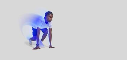 An african american athletic man is captured in a runner's starting position, isolated on a white backdrop photo