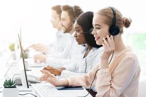 Team of helpline operators with headsets consulting clients at call center office, blank space photo