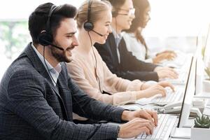 Telemarketing or hotline operators working with computers at modern office photo