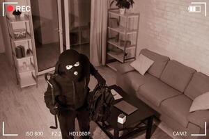 Being Caught. Robber entering house, holding crowbar and looking at CCTV camera, high angle view from above photo