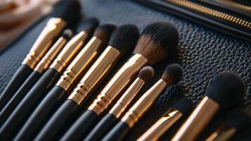 A set of carefully arranged makeup brushes with black handles and gold accents rests on a textured black leather case, showcasing various brush shapes for different applications. photo