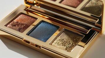 A beautiful eyeshadow palette with three shimmering shades rests on a soft surface. The golden casing reflects light, enhancing the rich tones of copper, blue, and gold. photo