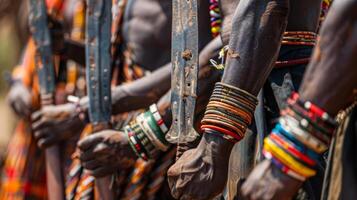 Warriors stand in a row, holding swords and showcasing their intricate body adornments while participating in a cultural ceremony in a vibrant village, highlighting traditions and community pride. photo